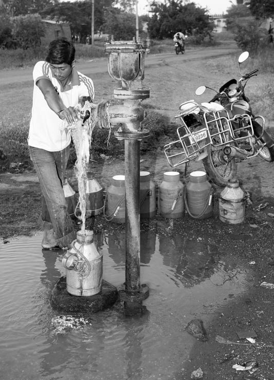 Men and Drinking Water Procurement - Filling containers at a valve on a water mainline in Ahmednagar district, Maharashtra